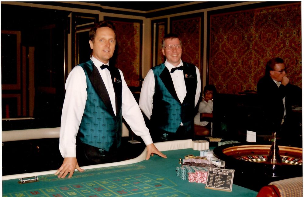Randy Rutecki, left, in a dealer's vest at a high-limit roulette table